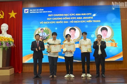 Phó Giáo sư, Tiến sĩ Lê Thành Bắc, Phó Giám đốc Đại học Đà Nẵng và Phó Giáo sư, Tiến sĩ Nguyễn Hữu Hiếu, Hiệu trưởng trường Đại học Bách khoa trao Giấy khen vinh danh các sinh viên xuất sắc. (Ảnh ANH ĐÀO)
