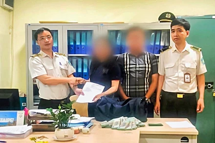 Anh Nguyễn Đức Tuệ (bên phải ảnh) và Đội trưởng Vũ Văn Diễn trao lại chiếc túi cho hành khách.