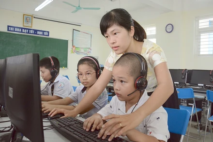 Cô giáo và học sinh tiểu học tại Hà Nội. (Ảnh minh họa: DUY LINH)