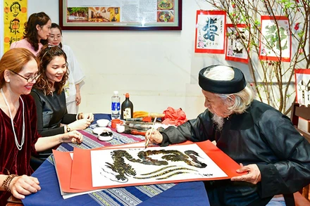 Nhà thư pháp Lê Thiên Lý cho chữ.