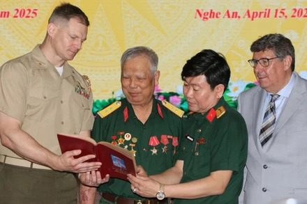 Cựu chiến binh Lê Đức Thuận (thứ 2, từ trái sang) xúc động khi nhận lại cuốn sổ ghi chép của mình.