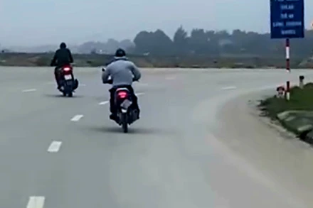 Đối tượng cướp (áo màu ghi) tẩu thoát bằng xe máy. (Ảnh cắt từ video clip)