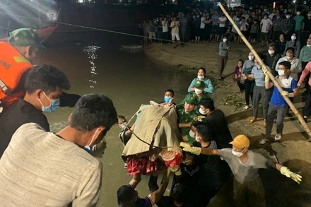 Lực lượng cứu hộ bàn giao thi thể 2 ngư dân cho gia đình.