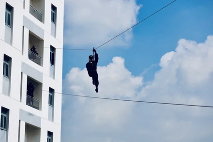 Bài tập đu dây qua các tòa nhà của các nữ chiến sĩ cảnh sát đặc nhiệm. Ảnh: NAM VY