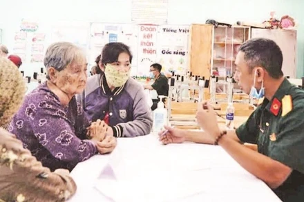 Bác sĩ quân y Phạm Văn Dũng (Cục 12) khám chữa bệnh cho người có công. (Ảnh ANH THẾ)