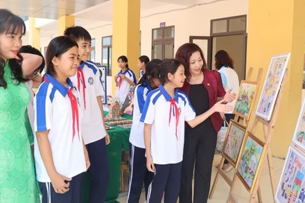 Học sinh và lãnh đạo Hội Phụ nữ tham quan góc truyền thông về các vấn đề phòng ngừa, ứng phó với bạo lực học đường.