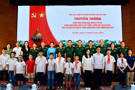 Các đại biểu chụp ảnh lưu niệm với trẻ em được nhận đỡ đầu. 