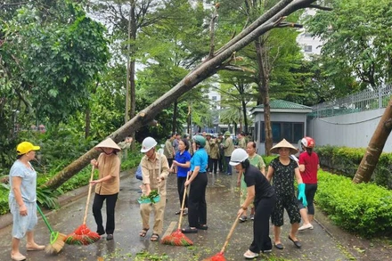 Phụ nữ quận Bắc Từ Liêm quét dọn vệ sinh môi trường sau bão số 3. 