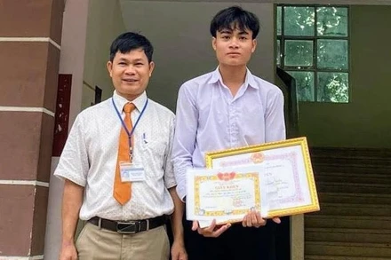 Đại diện Ban giám hiệu Trường Trung học phổ thông Nguyễn Du trao giấy khen cho em Kpắ Y Sem.