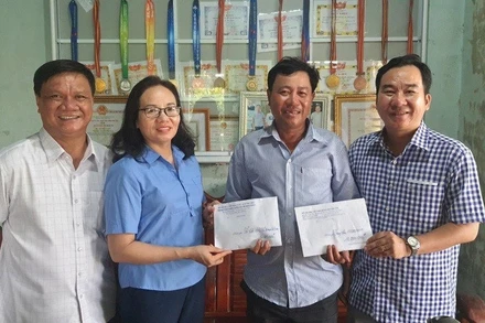 Đại diện gia đình vận động viên Lê Thị Tuyết tiếp nhận quà của lãnh đạo Sở Văn hóa-Thể thao, Du lịch Phú Yên trao chúc mừng.