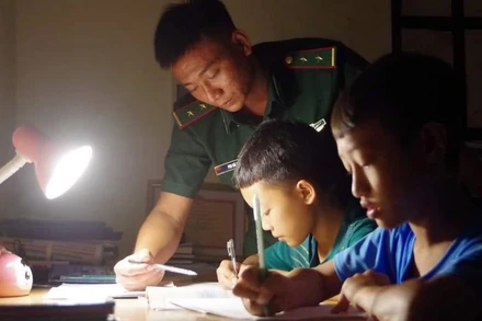 Những người "cha đỡ đầu" của Đồn Biên phòng Pa Ủ dạy các con học bài.