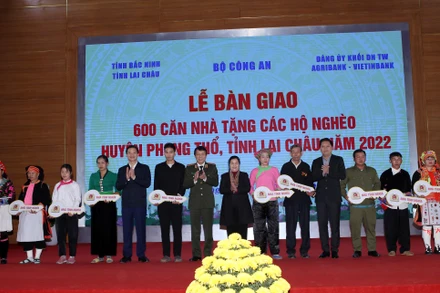 Lãnh đạo Bộ Công an, tỉnh Lai Châu và các nhà tài trợ trao tượng trưng chìa khóa cho các hộ nghèo.