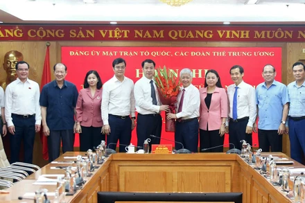 Đồng chí Đỗ Văn Chiến (thứ 5 từ phải sang) và đại diện các ban, ngành, đoàn thể tặng hoa chúc mừng Phó Bí thư chuyên trách Đảng ủy Mặt trận Tổ quốc, các đoàn thể Trung ương Ngô Văn Cương.