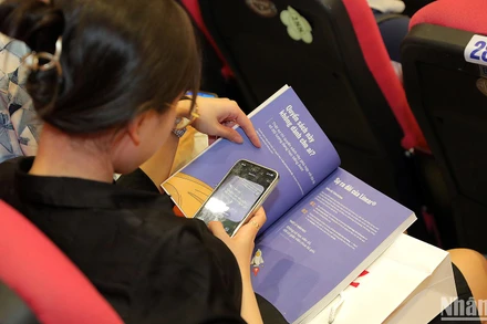 Các giáo viên trẻ sử dụng công nghệ để nghiên cứu tài liệu học thuật tại buổi tập huấn.