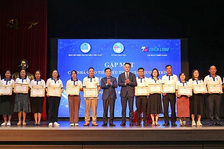 Thứ trưởng, Phó Chủ nhiệm Ủy ban Dân tộc Nông Quốc Tuấn và Phó Chủ tịch Thường trực Hội Liên hiệp thanh niên Việt Nam Nguyễn Kim Quy (thứ 8 và 9 từ trái sang) trao Kỷ niệm chương “Vì sự nghiệp phát triển các dân tộc” tặng một số đại diện giáo viên được tuyên dương. 