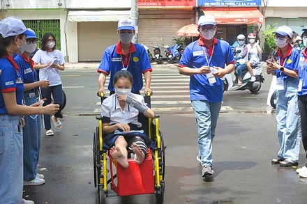 Lực lượng tình nguyện viên "Tiếp sức mùa thi" tại Thành phố Hồ Chí Minh hỗ trợ thí sinh đến phòng thi an toàn.