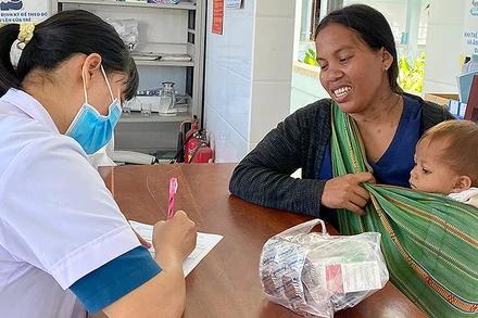 Cán bộ y tế khám, tư vấn sức khỏe cho bà mẹ và trẻ em vùng cao.