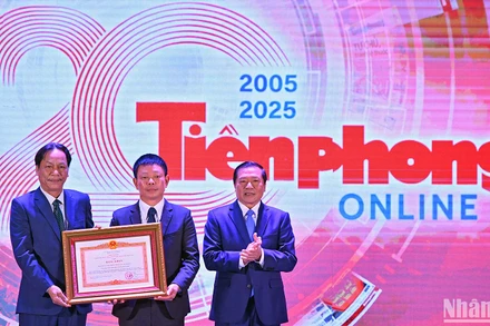 Đồng chí Lại Xuân Môn (bên phải) trao Bằng khen của Thủ tướng Chính phủ tặng đại diện lãnh đạo Báo Tiền Phong tại buổi lễ.