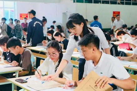 Các em tân sinh viên làm thủ tục nhập học với sự hướng dẫn tận tình của các thầy, cô giáo.