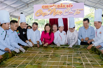 Lãnh đạo thành phố Cần Thơ cùng các nghệ nhân bên chiếc bánh chưng khổng lồ tại lễ hội.