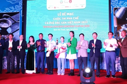 Hai thí sinh đoạt giải Nhất Cuộc thi pha chế cà-phê đặc sản Việt Nam năm 2023 Trương Thị Thiện và Phạm Ngọc Thạch chụp hình với các đồng chí lãnh đạo tỉnh Đắk Lắk và Ban tổ chức cuộc thi tại lễ bế mạc.