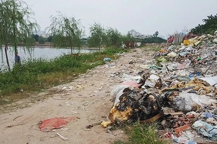 Nạn đổ trộm rác thải diễn ra ở nhiều nơi. (Ảnh: Báo Nhân Dân)