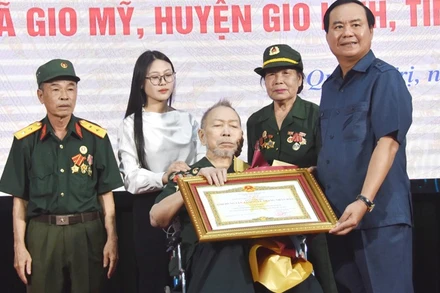 Đồng chí Võ Văn Hưng trao quyết định của Chủ tịch nước tặng danh hiệu Anh hùng lực lượng vũ trang nhân dân cho ông Dương Bá Quy. 