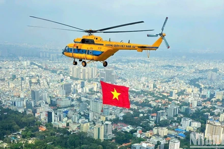 Máy bay trực thăng kéo cờ Tổ quốc luyện tập trên bầu trời Thành phố Hồ Chí Minh.