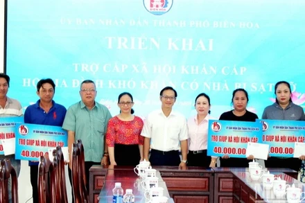 Lãnh đạo thành phố Biên Hòa trao số tiền hỗ trợ cho 4 hộ dân.
