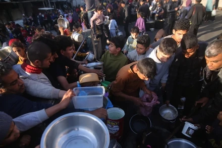 Người dân chờ được phát thực phẩm cứu trợ tại thành phố Rafah, Dải Gaza. (Ảnh: THX/TTXVN)