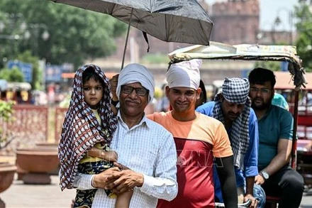 Người dân che ô tránh nắng nóng tại New Delhi, Ấn Độ, ngày 21/5/2024. (Ảnh: AFP/TTXVN)