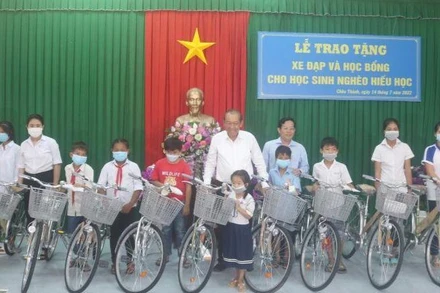 Nguyên Ủy viên Bộ Chính trị, Nguyên Phó Thủ tướng Thường trực Chính phủ Trương Hòa Bình trao xe đạp cho học sinh huyện Châu Thành, tỉnh Trà Vinh.