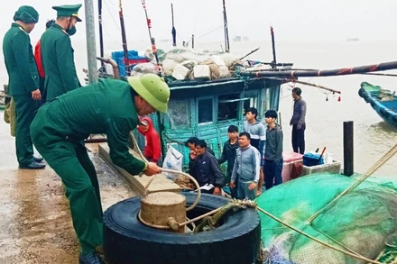 Cán bộ Đồn Biên phòng Roòn thăm hỏi ngư dân được cứu nạn an toàn.