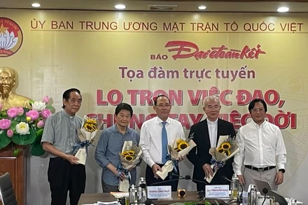 Tổng Biên tập Báo Đại Đoàn Kết Lê Anh Đạt tặng hoa các đại biểu dự Tọa đàm.