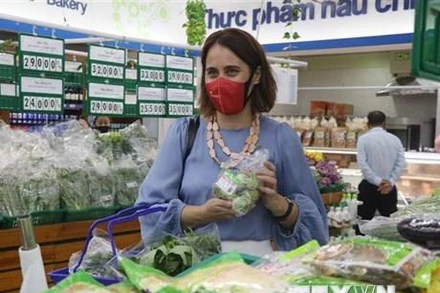 Đại sứ New Zealand tại Việt Nam Tredene Dobson mua rau an toàn tại siêu thị Co.op Mart Quy Nhơn do nông dân Bình Định sản xuất từ dự án Rau an toàn Bình Định. (Ảnh: Kha Phạm/TTXVN)