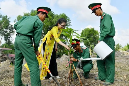 Cán bộ, chiến sĩ Trung đoàn Bộ binh 893 và thanh niên, phụ nữ trên địa bàn đơn vị đóng quân cùng tham gia trồng cây xanh. 