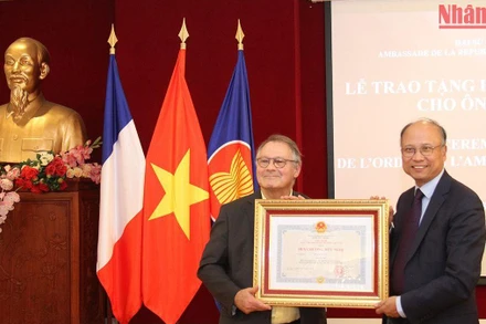 Đại sứ Đinh Toàn Thắng trao Huân chương Hữu nghị cho nhà sử học Alain Ruscio. (Ảnh: Khải Hoàn)