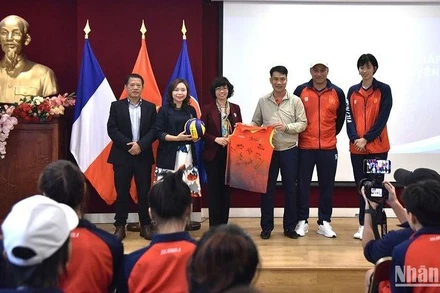Đại sứ-Trưởng Phái đoàn thường trực Việt Nam bên cạnh UNESCO, Lê Thị Hồng Vân, nhận món quà từ đội tuyển bóng chuyển nữ Việt Nam dành tặng cho Đại sứ quán Việt Nam tại Pháp. (Ảnh: MINH DUY)