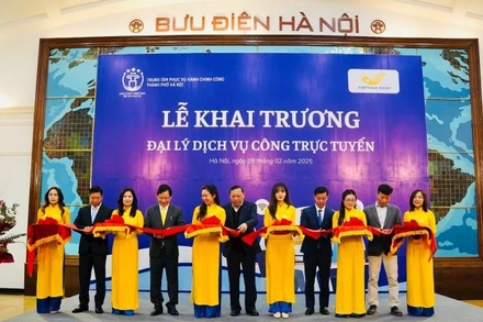 Các đại biểu thực hiện nghi thức khai trương đại lý dịch vụ công trực tuyến tại số 75 phố Đinh Tiên Hoàng (quận Hoàn Kiếm). (Ảnh: T.Hà)