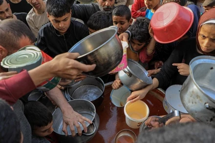 Người dân chờ nhận lương thực viện trợ ở thành phố Rafah, phía Nam dải Gaza. (Ảnh: THX/TTXVN)