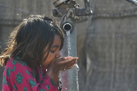 Em nhỏ uống nước từ vòi nước công cộng ở Lahore, Pakistan. (Ảnh: AFP/TTXVN)