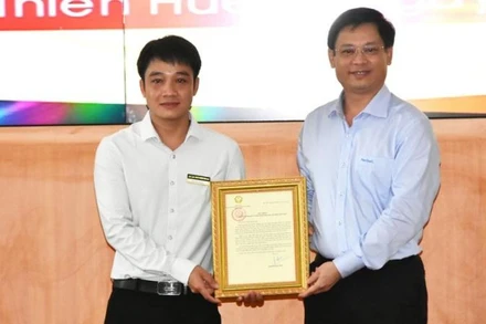 Phó Chủ tịch Thường trực UBND tỉnh Thừa Thiên Huế Nguyễn Thanh Bình (bên phải) trao Thư khen của Chủ tịch nước cho anh Tô Vũ Đồng.