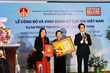 Tổ chức Kỷ lục Việt Nam (VietKings) trao bằng chứng nhận cho cụ bà Phạm Thị Ngọc Cầm. (Ảnh: Phương Hà/TTXVN)