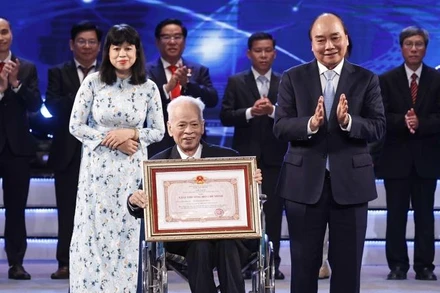 Chủ tịch nước Nguyễn Xuân Phúc trao Giải thưởng Hồ Chí Minh cho Giáo sư, Tiến sĩ khoa học Nguyễn Quang Hồng, tác giả công trình "Tự điển chữ Nôm dẫn giải". (Ảnh: Thống Nhất/TTXVN)