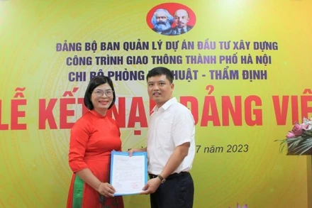Bí thư Chi bộ Phòng Kỹ thuật-Thẩm định (Ban Quản lý dự án đầu tư xây dựng công trình giao thông thành phố Hà Nội) trao Quyết định kết nạp đảng cho đồng chí Bùi Thị Phương Ngọc. Ảnh: Linh Nguyễn