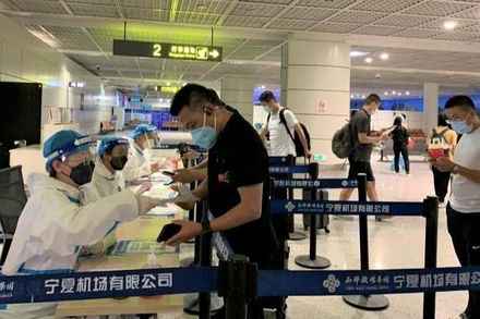 Hành khách làm thủ tục kiểm tra xét nghiệm SARS-CoV-2 tại sân bay ở thành phố Ngân Xuyên, Trung Quốc. (Ảnh: HỮU HƯNG)