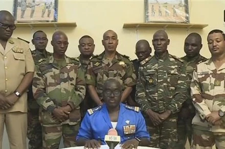 Đại tá Amadou Abdramane (ngồi), Người Phát ngôn của Hội đồng Quốc gia Bảo vệ Tổ quốc (CNSP) tại Niger, tuyên bố đảo chính trên truyền hình quốc gia ngày 26/7. (Ảnh: AFP/TTXVN)