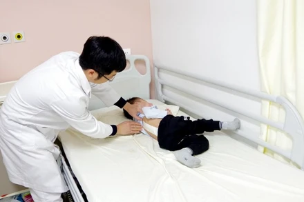 Khám cho trẻ cong vẹo cột sống.