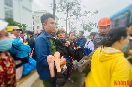 Công an xã Bình Đông đưa người bệnh từ nơi trú bão lên xe ô-tô để về nhà.