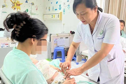 Phó Giáo sư, Tiến sĩ Nguyễn Việt Hoa thăm khám cho trẻ. 